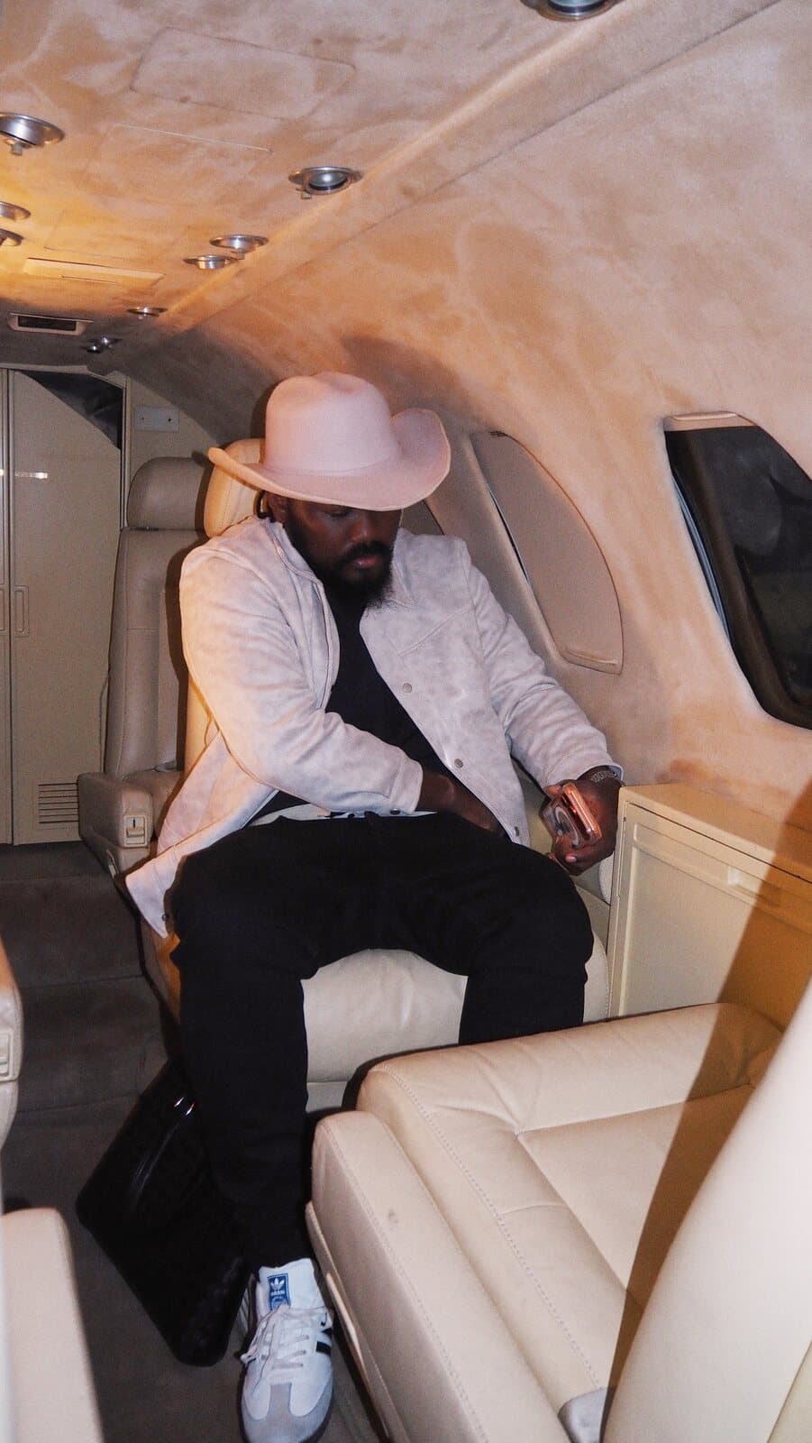 ABJKOREA seated in a private jet cabin, taking a call.