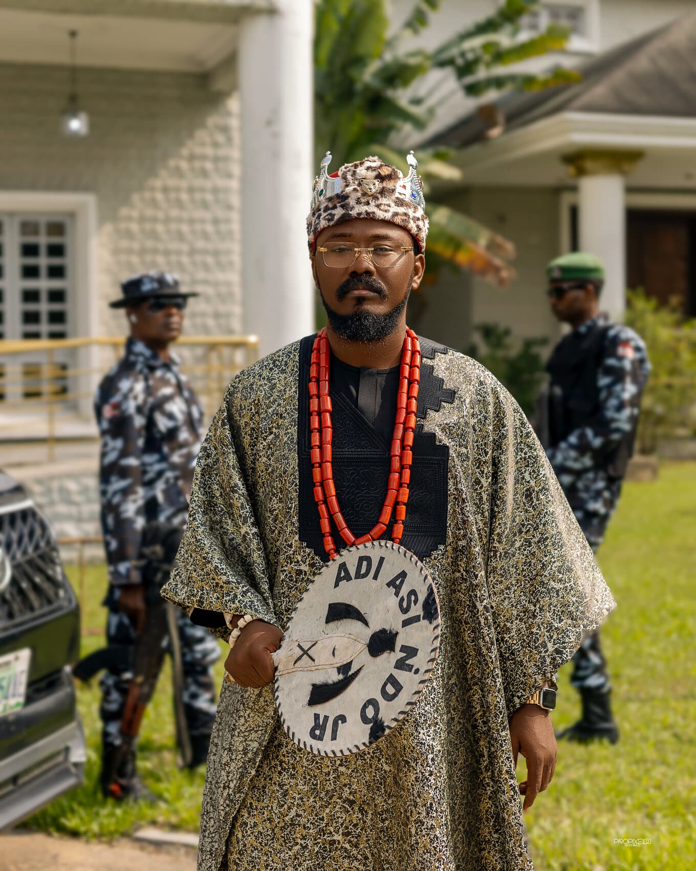ABJKOREA in chieftaincy regalia on a development site, reviewing his phone.